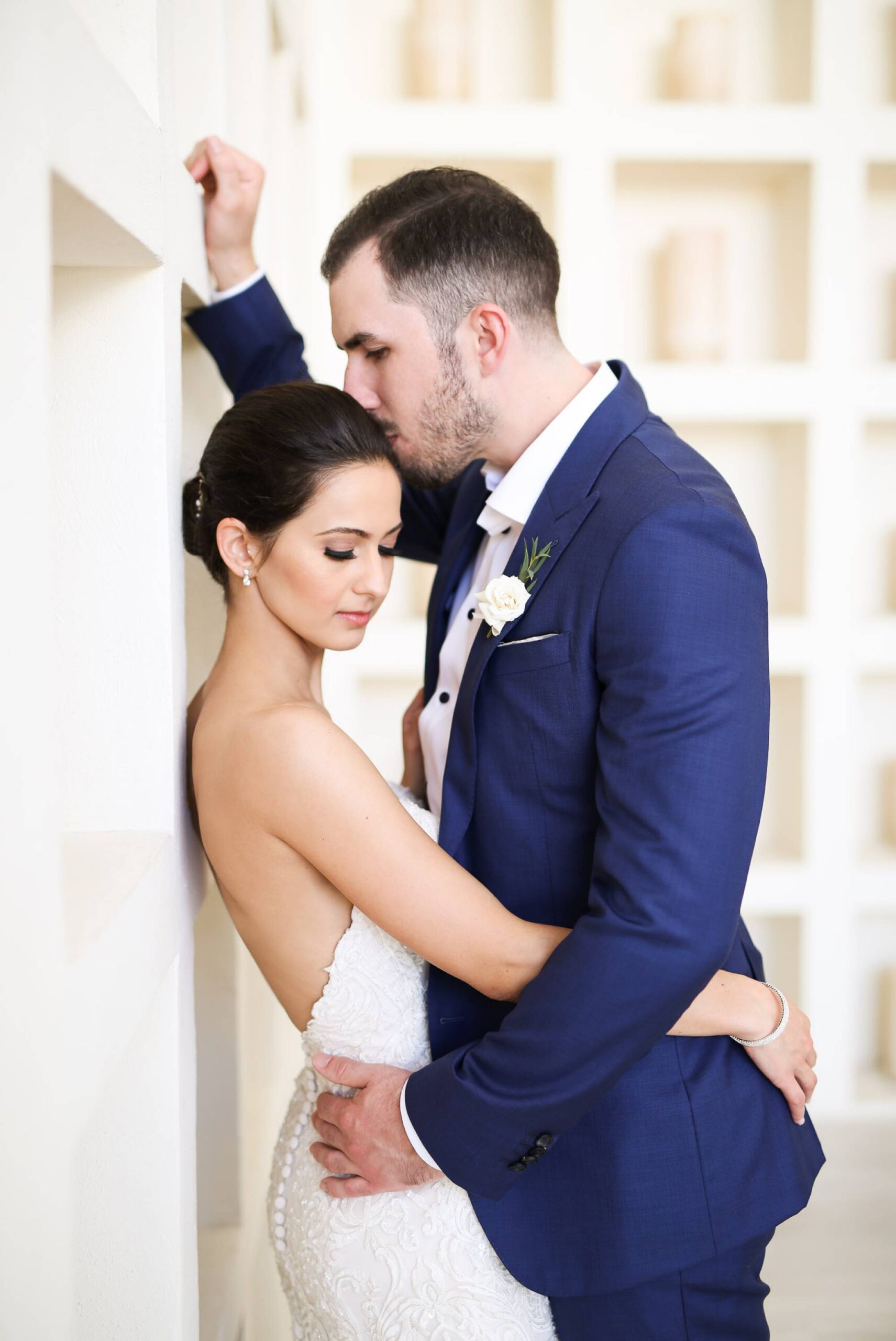 Groom kisses bride on forehead, wedding day