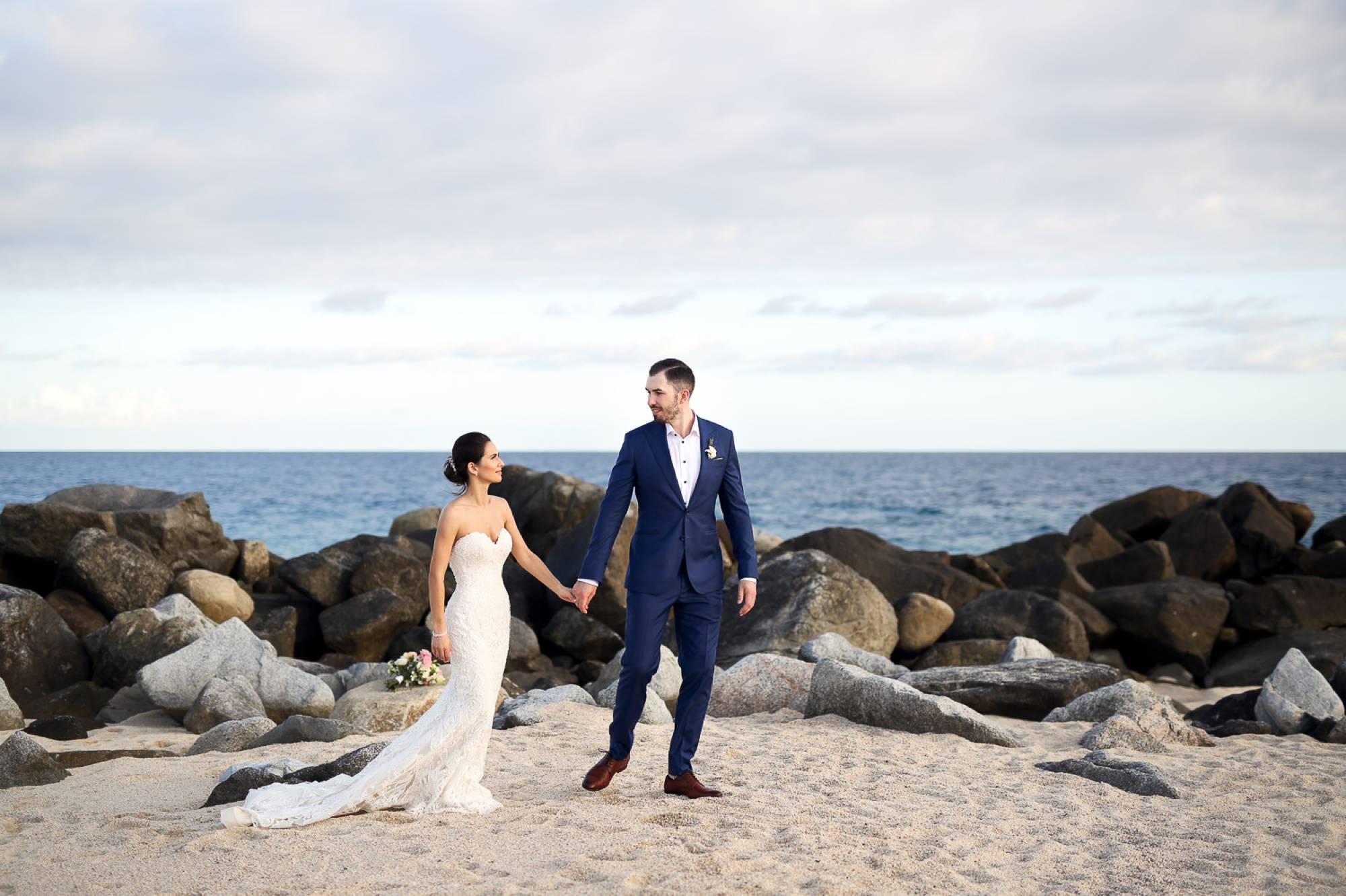 Couple walking on beach on their wedding day