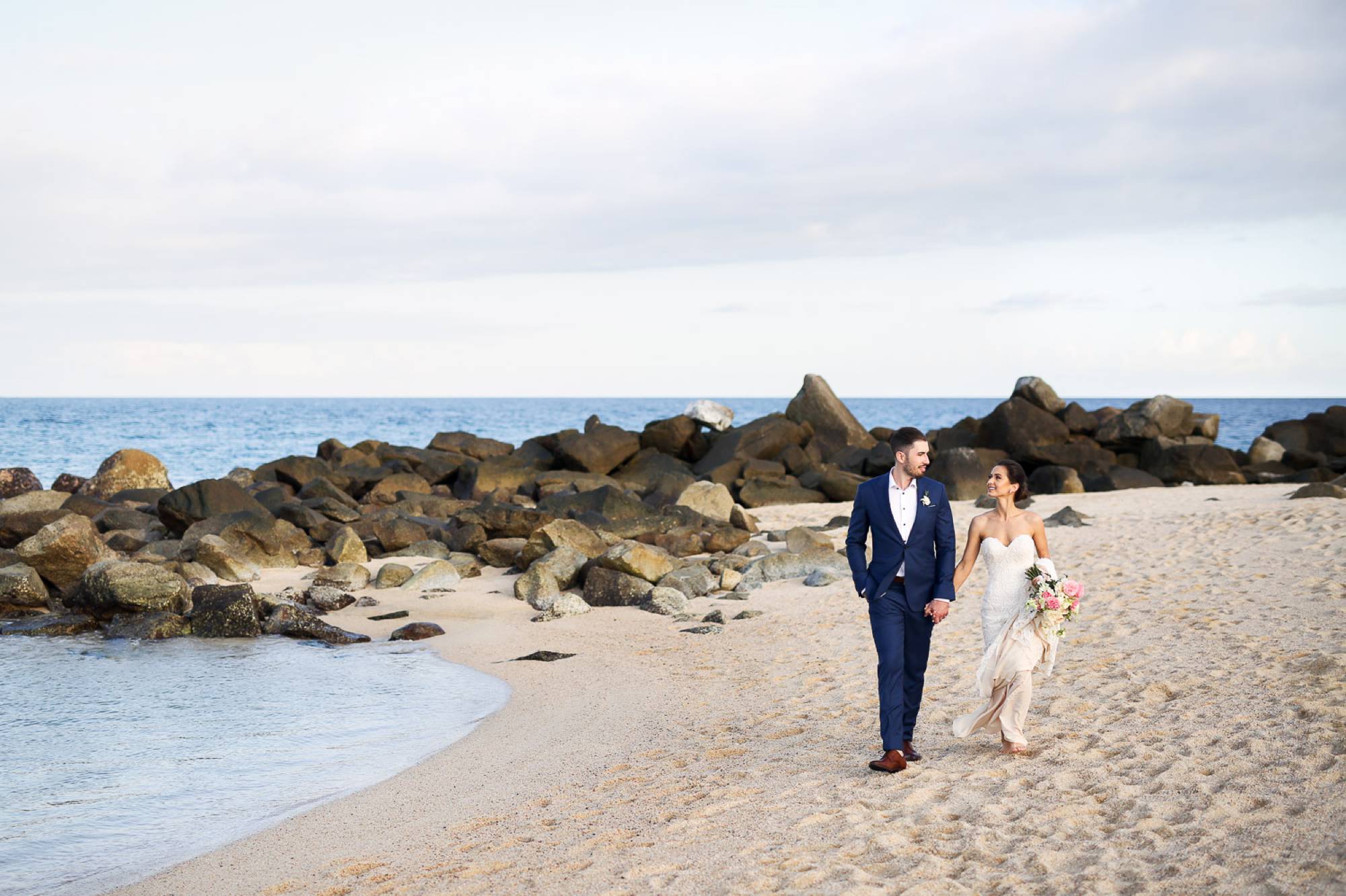 Couple walking to reception on beach